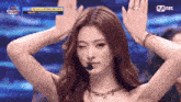 a woman with a microphone in front of her face and a mnet logo