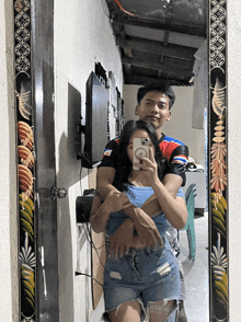 a man and a woman are taking a selfie in a mirror