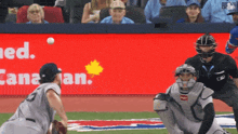 a baseball game is being played in front of a sign that says canada