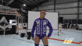 a wrestler in a purple outfit with the letters e and k on it