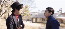 a man in a top hat is talking to another man in a suit