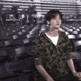 a man wearing a camo jacket is sitting in a stadium