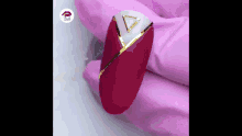a close up of a nail with a gold triangle on it .