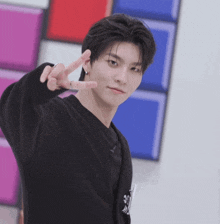 a young man wearing a black shirt with the number 30 on it giving a peace sign