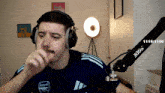 a man wearing headphones and a blue shirt that says arsenal on it