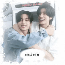 two young men hugging in front of a video game