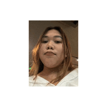 a woman with long hair is taking a selfie with her phone .