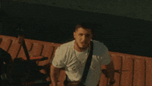 a man wearing a white t-shirt with a necklace around his neck