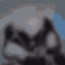 a blurred image of a person 's face with a blue sky in the background