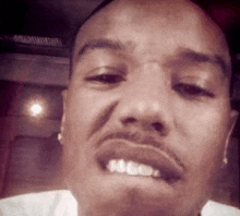 a close up of a man 's face with his mouth open and his teeth visible
