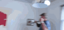 a man is fixing a ceiling fan in a room