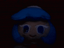 a stuffed animal with blue hair and white eyes in the dark .