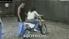 a woman is riding a dirt bike on a dirt road .