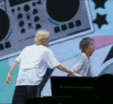 a couple of people standing next to each other on a stage .
