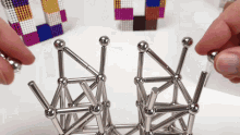 a person is playing with magnetic balls and sticks on a table