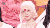 a woman wearing a white hat with a heart on her forehead