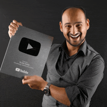 a man is holding up a youtube award