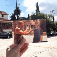 a person is holding a picture of two men having a conversation