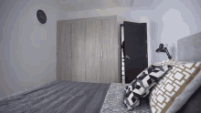 a bedroom with a bed and a clock on the wall that says 10:08