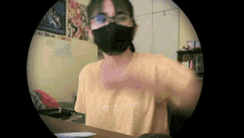a person wearing a mask and a yellow shirt that says freedom trust