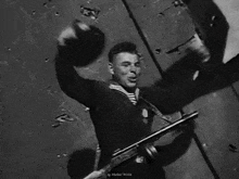 a black and white photo of a soldier holding a gun on his back .