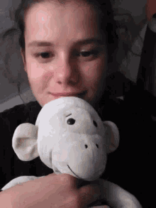 a woman is holding a stuffed monkey in her arms