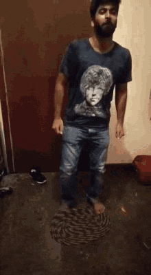a man with a beard wearing a shirt with a picture of john lennon