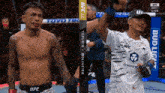 two ufc fighters standing next to each other on a stage