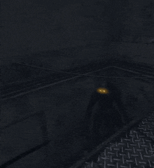 a dark room with a metal floor and a shadow of a person