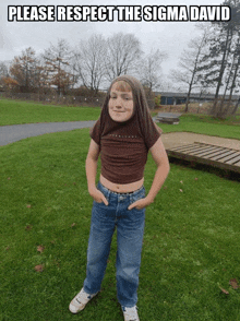 a boy wearing a crop top and jeans is standing in a grassy field with a caption that says please respect the sigma david