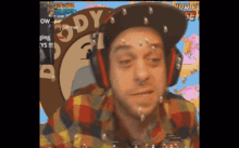 a man wearing headphones and a hat that says body