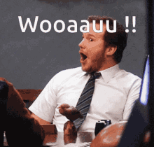 a man in a white shirt and tie is sitting at a table with his mouth open and the word wooaauu written above him