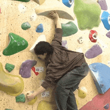 a person on a climbing wall with a number 17 on the wall
