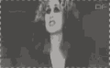 a black and white photo of a woman with big eyes and the letters of on the bottom