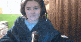 a young girl wearing headphones and a blue robe