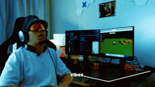 a man wearing headphones and sunglasses is sitting in front of two computer monitors and says vibes
