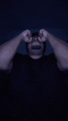 a man wearing glasses and a beanie is making a face