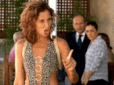 a woman in a leopard print one piece swimsuit is making a face