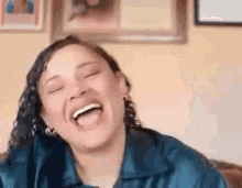 a woman is laughing with her eyes closed and her tongue out in a living room .