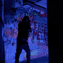a person standing in front of a wall with graffiti on it that says ' i love you '