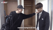 two men are standing next to each other in front of a closet . one of the men is trying to act dark .