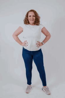 a woman standing with her hands on her hips wearing a watch