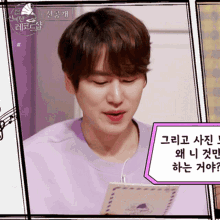 a man in a purple shirt is holding a piece of paper with korean writing on it