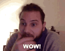 a man with a beard is making a surprised face and saying wow .