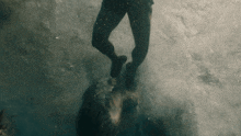 a person is standing in the water with their feet in the air