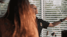 a man in a police uniform stands in front of a woman with long red hair