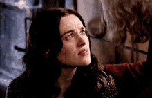 a close up of a woman 's face with a sad look on her face .