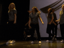 a man in a wheelchair is watching two women dance