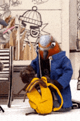 a stuffed bird in a blue coat is kneeling down with a yellow backpack