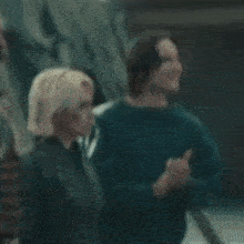 a man and a woman are standing next to each other and clapping .